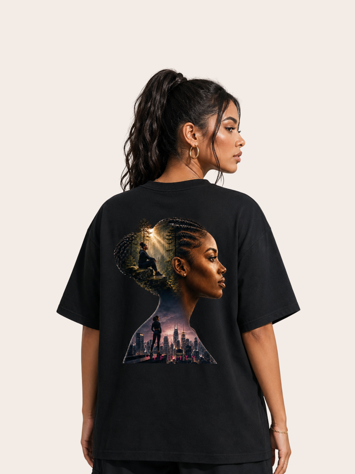 Schwarzes VYFINITY Oversized T-Shirt mit großem Rückenprint einer schwarzen Frau im Seitenprofil mit geflochtenem Haar. In die Silhouette sind ein lichtdurchfluteter Wald und eine urbane Skyline integriert. Weibliches Model in Rückenansicht vor hellem, minimalistischem Hintergrund.