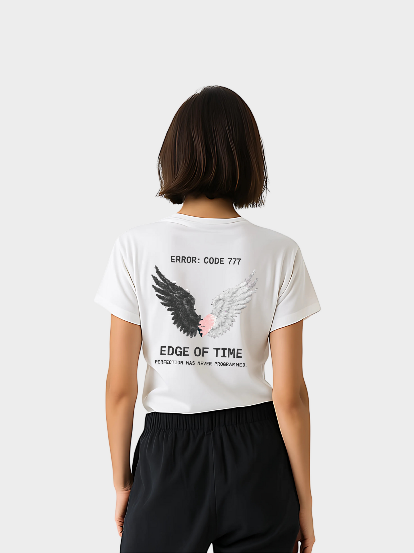Vyfinity Edge of Time T-Shirt in Weiß, Rückseite. Künstlerischer Print mit schwarzen und weißen Engelsflügeln, einem rosa Herz in der Mitte und den Schriftzügen „Error: Code 777“, „Edge of Time“ und „Perfection was never programmed“. Moderner Oversize-Streetwear Look.