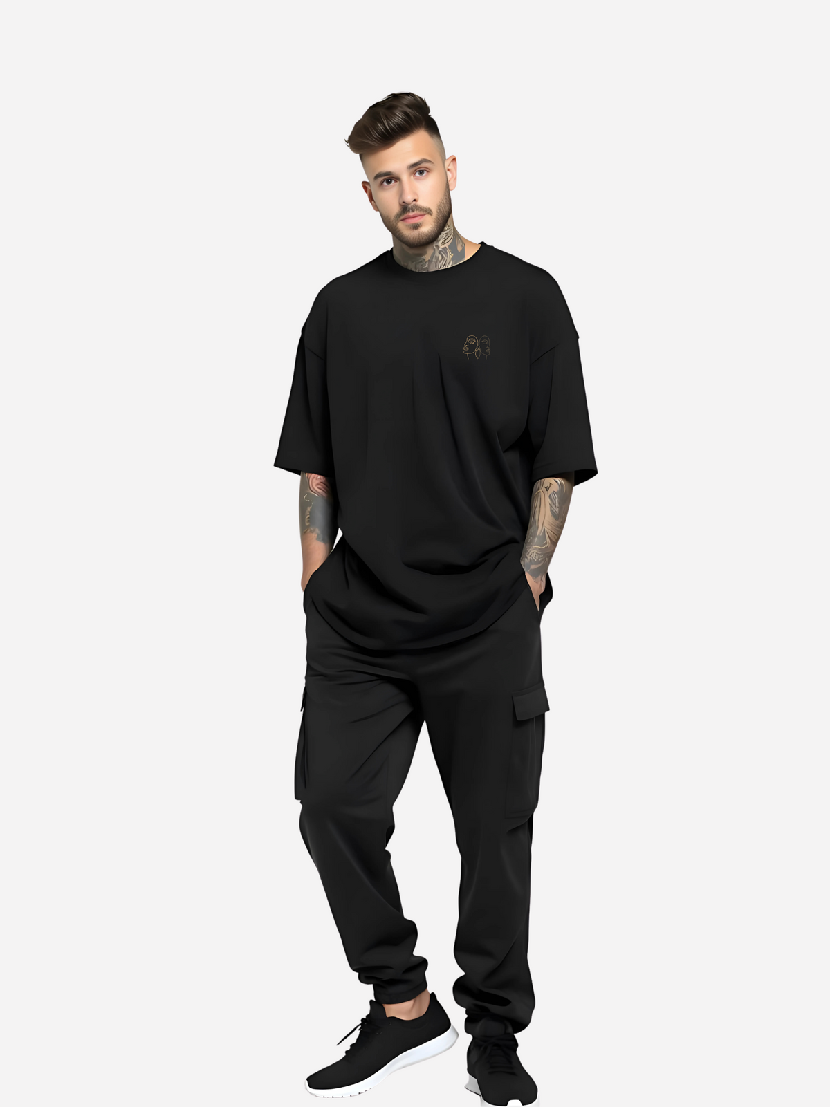Vyfinity Oversize T-Shirt in Schwarz mit kleinem Line-Art Brustlogo, getragen von tätowiertem Model in schwarzer Cargo-Jogginghose und Sneakers. Moderner Streetwear-Look, Ganzkörperansicht.