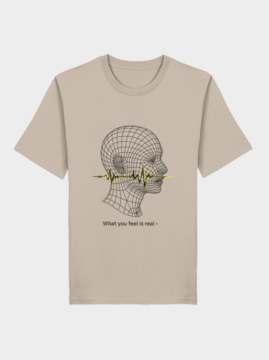 Beiges Vyfinity Unisex T-Shirt mit futuristischem Linienkopf-Motiv. Durch den Kopf verläuft eine gelbe Soundwave, darunter der Schriftzug „What you feel is real –“. Minimalistisches Graphic Tee im modernen Streetwear-Stil.