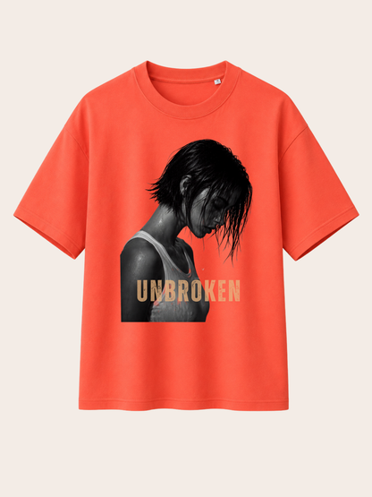 Korallenrotes Vyfinity Relaxed Fit T-Shirt mit großem „UNBROKEN“-Frontprint. Hochwertiges Unisex Baumwollshirt mit ausdrucksstarkem Schwarz-Weiß-Porträt einer Frau und goldener Typografie im modernen Premium Streetwear- und Urban Fashion Design.