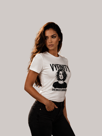 Frau trägt ein weißes Vyfinity T-Shirt mit SHE BUILDS EMPIRES Print und stilisiertem Frauenporträt. Hochwertiges Damen Baumwollshirt im modernen Streetwear- und Empowerment-Design.