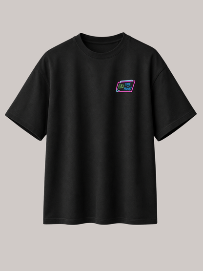 Schwarzes VYFINITY Oversized Unisex T-Shirt mit kleinem „Time Is Money“ Brustlogo in Neonfarben auf der Vorderseite. Minimalistisches Premium Streetwear Design aus hochwertiger Bio-Baumwolle mit Relaxed Fit – freigestelltes Produktbild auf neutralem Hintergrund.