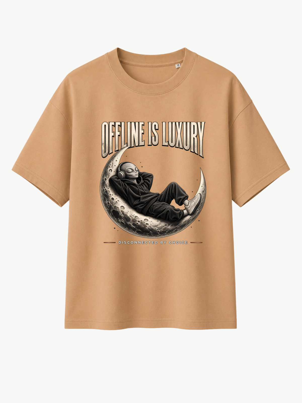 Sandfarbenes Oversized T-Shirt mit großem „OFFLINE IS LUXURY“-Frontprint. Das Motiv zeigt eine entspannte Alien-Figur im Hoodie mit Kopfhörern auf einer detailreichen Mondsichel. Darunter steht „DISCONNECTED BY CHOICE“. Moderner VYFINITY Streetwear-Look.