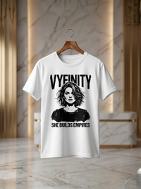 Weißes Vyfinity Damen T-Shirt mit SHE BUILDS EMPIRES Print auf Holzkleiderbügel. Hochwertiges Baumwollshirt mit modernem Streetwear- und Empowerment-Design in luxuriöser Produktpräsentation.