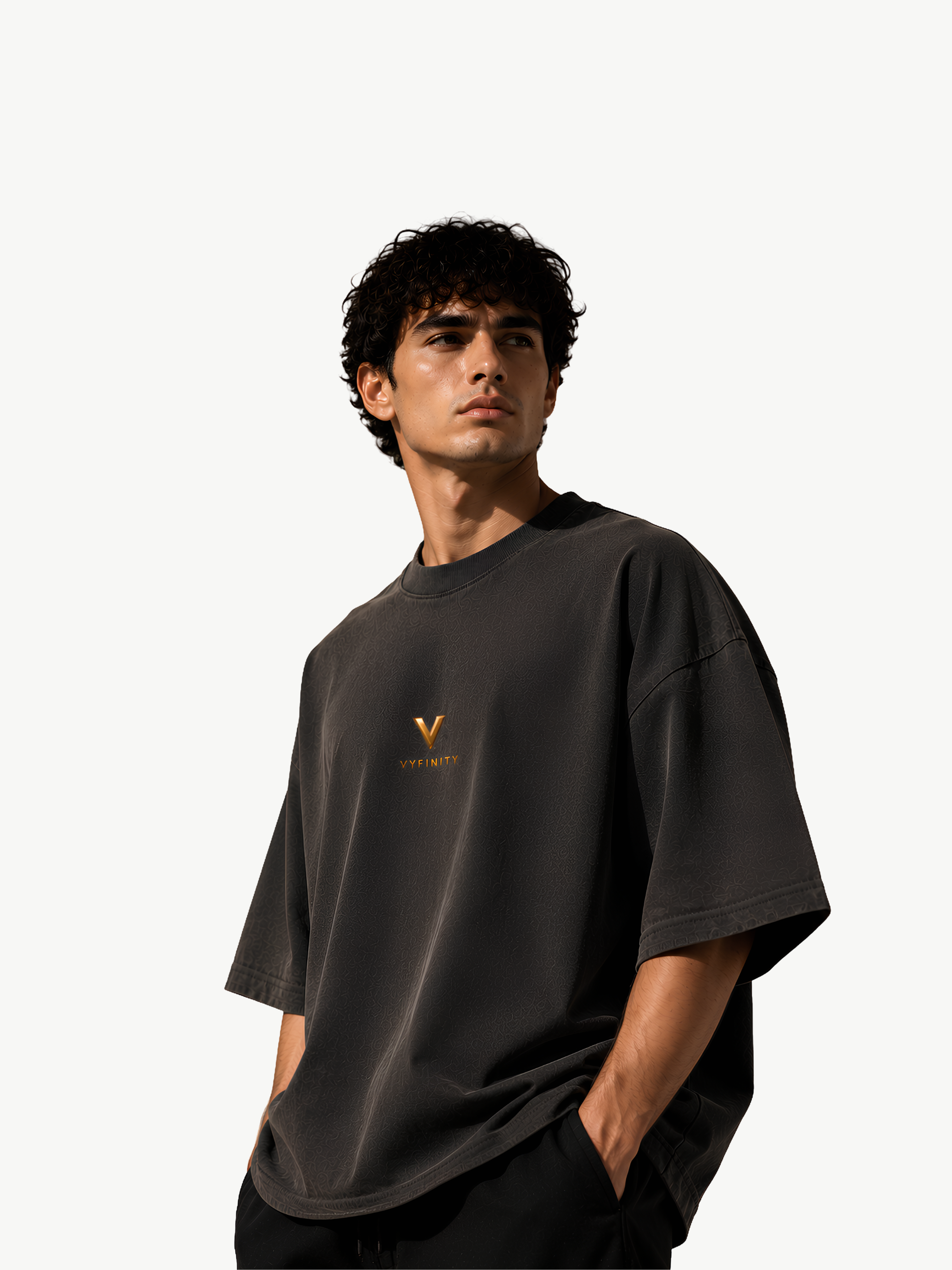 Junges männliches Model trägt ein dunkelgraues Vyfinity Oversized T-Shirt mit kleinem goldenen Vyfinity-Logo auf der Brust. Hochwertiges Premium-Streetwear-Shirt im minimalistischen Quiet-Luxury-Design mit lockerer Oversized-Passform aus Baumwolle – moderne Unisex Fashion für Alltag und Lifestyle.