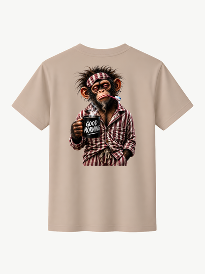 Beiges VYFINITY T-Shirt in Rückansicht mit großem „Good Morning“-Print: müder Affe im rot-weiß karierten Pyjama mit Zahnbürste und dampfender schwarzer Kaffeetasse. Heller minimalistischer Hintergrund.