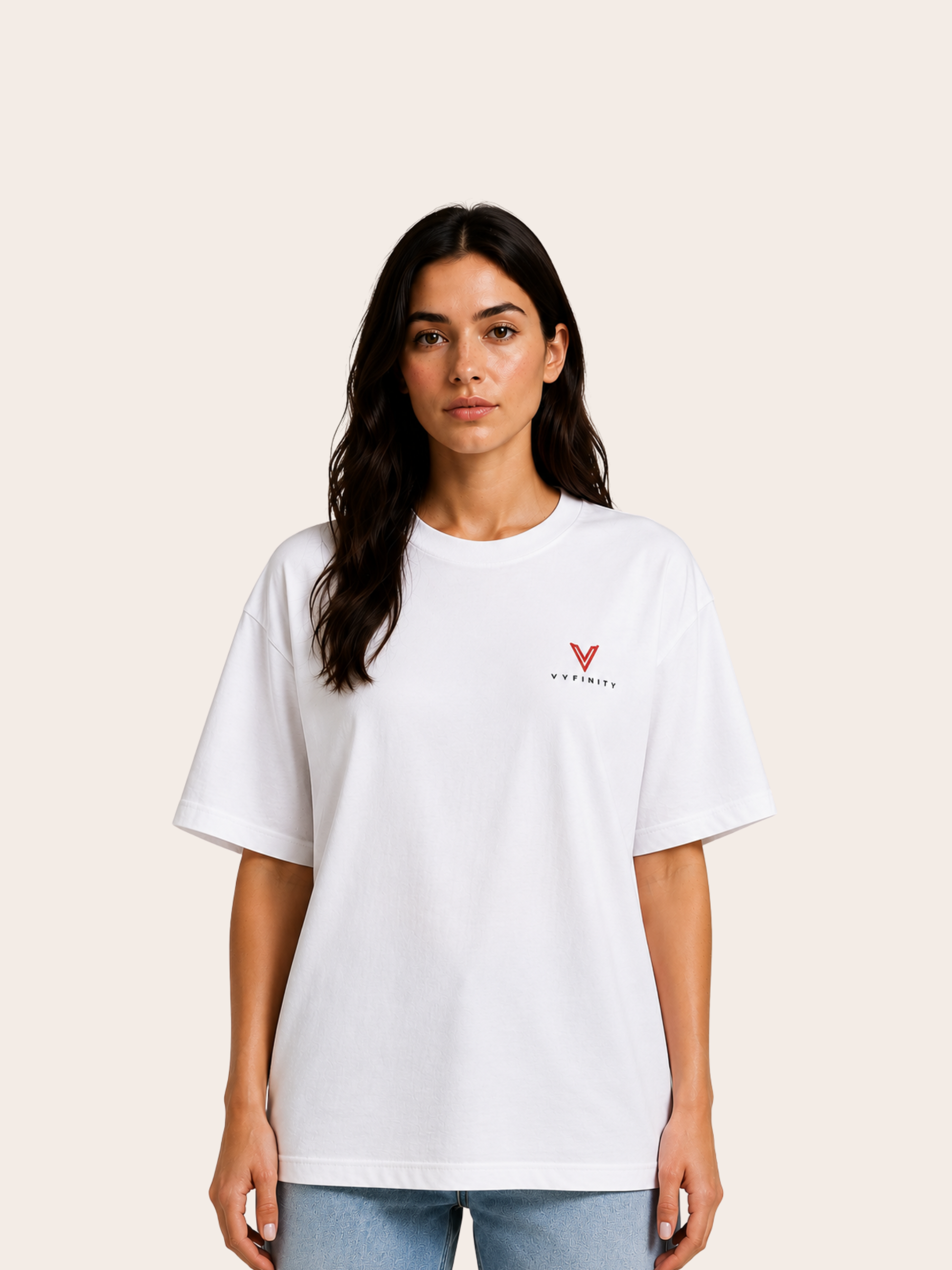 „Frau trägt weißes VYFINITY Relaxed Fit T-Shirt mit kleinem rotem VYFINITY Logo auf der Brust.“
