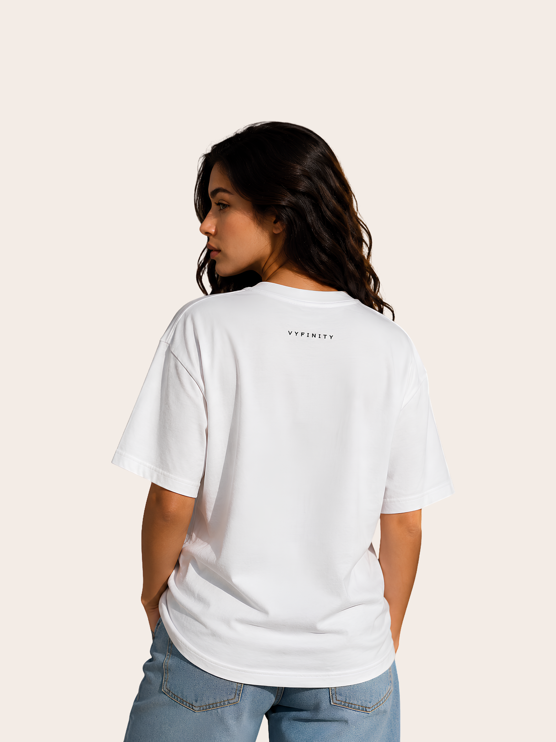 „Rückansicht einer Frau in einem weißen VYFINITY Relaxed Fit T-Shirt mit kleinem schwarzem VYFINITY Schriftzug im Nackenbereich.“