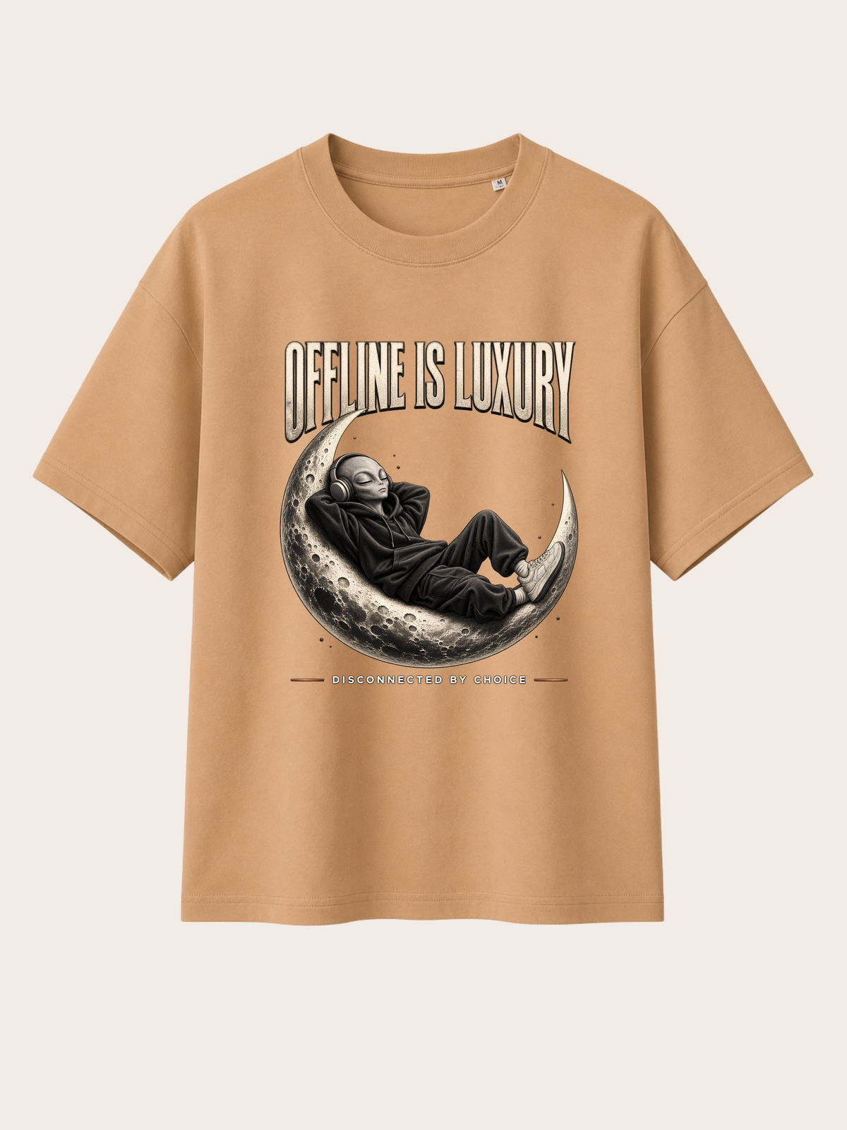 Sandfarbenes / warmes Beige Oversized Heavy T-Shirt mit großem Frontprint „OFFLINE IS LUXURY“. Zentrales Motiv: entspannter Alien im schwarzen Oversized Hoodie mit Kopfhörern, liegend auf einer detaillierten Mondsichel. Darunter der Schriftzug „DISCONNECTED BY CHOICE“. Cremefarbene Vintage-Typografie, monochromes Schwarz-Grau-Motiv und dezente warme Akzente. Rückseite ohne Print.