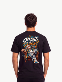 Männliches Model trägt ein schwarzes VYFINITY T-Shirt in Rückenansicht mit großem, farbenfrohem „OFFLINE IS LUXURY“-Design. Das Motiv zeigt einen entspannt im Ledersessel sitzenden Mann mit Kopfhörern und auffälligen Orange-, Blau- und Weißtönen vor weißem Studiohintergrund.
