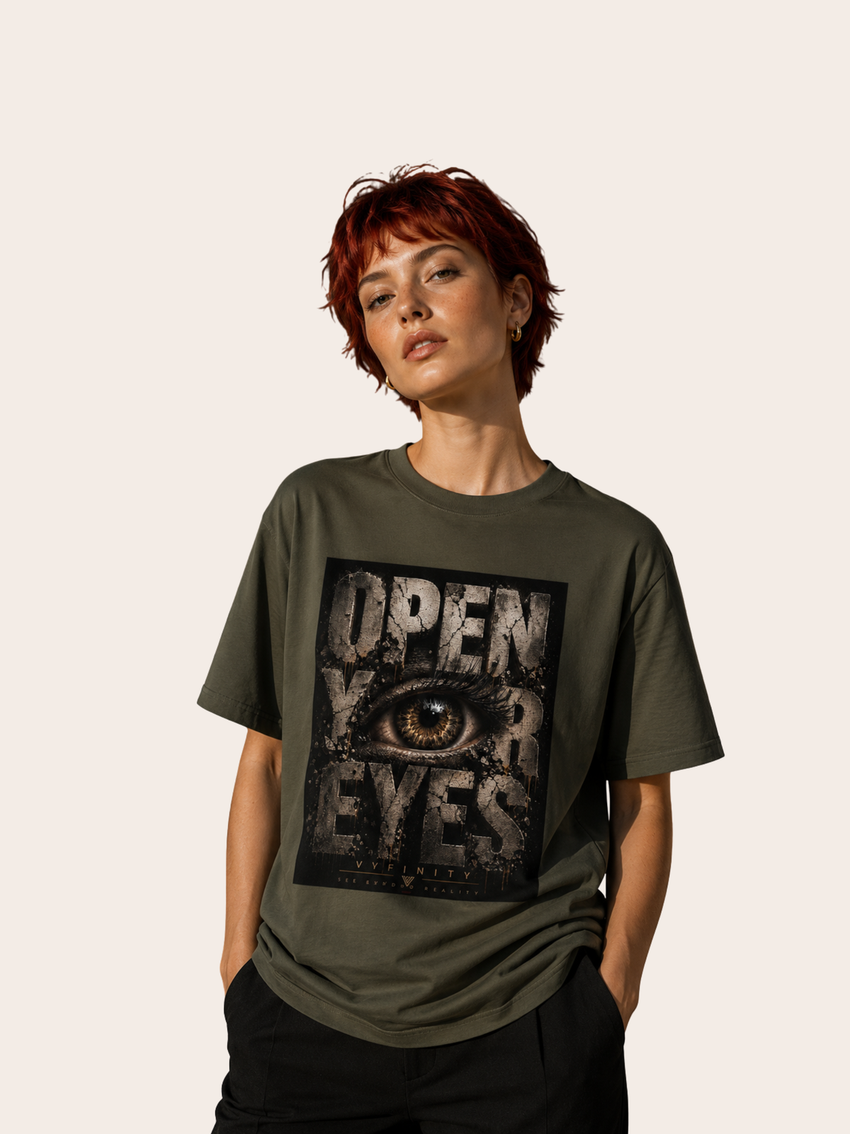 Frau mit kurzem rotem Haar trägt ein olivgrünes VYFINITY T-Shirt mit großem „OPEN YOUR EYES“-Frontprint. Das markante Design zeigt ein realistisches Auge in dunkler Grunge-Optik mit VYFINITY-Branding.