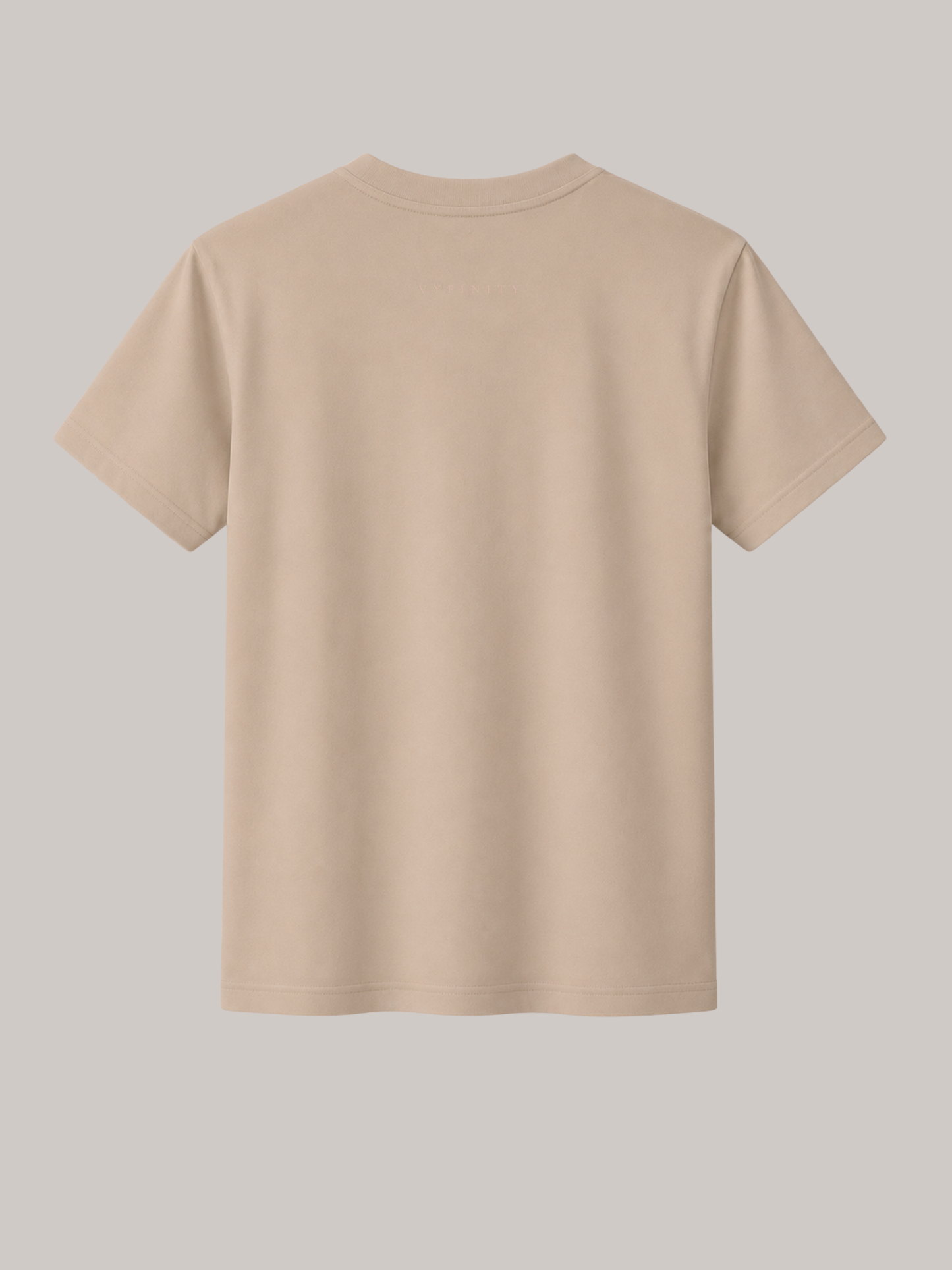 Rückansicht eines beigen Unisex Classic Fit T-Shirts aus hochwertiger Baumwolle mit dezentem VYFINITY-Schriftzug im Nacken. Minimalistisches Premium Streetwear-Shirt für Damen und Herren mit cleanem Design, Regular Fit und modernem Luxury Fashion Stil.
