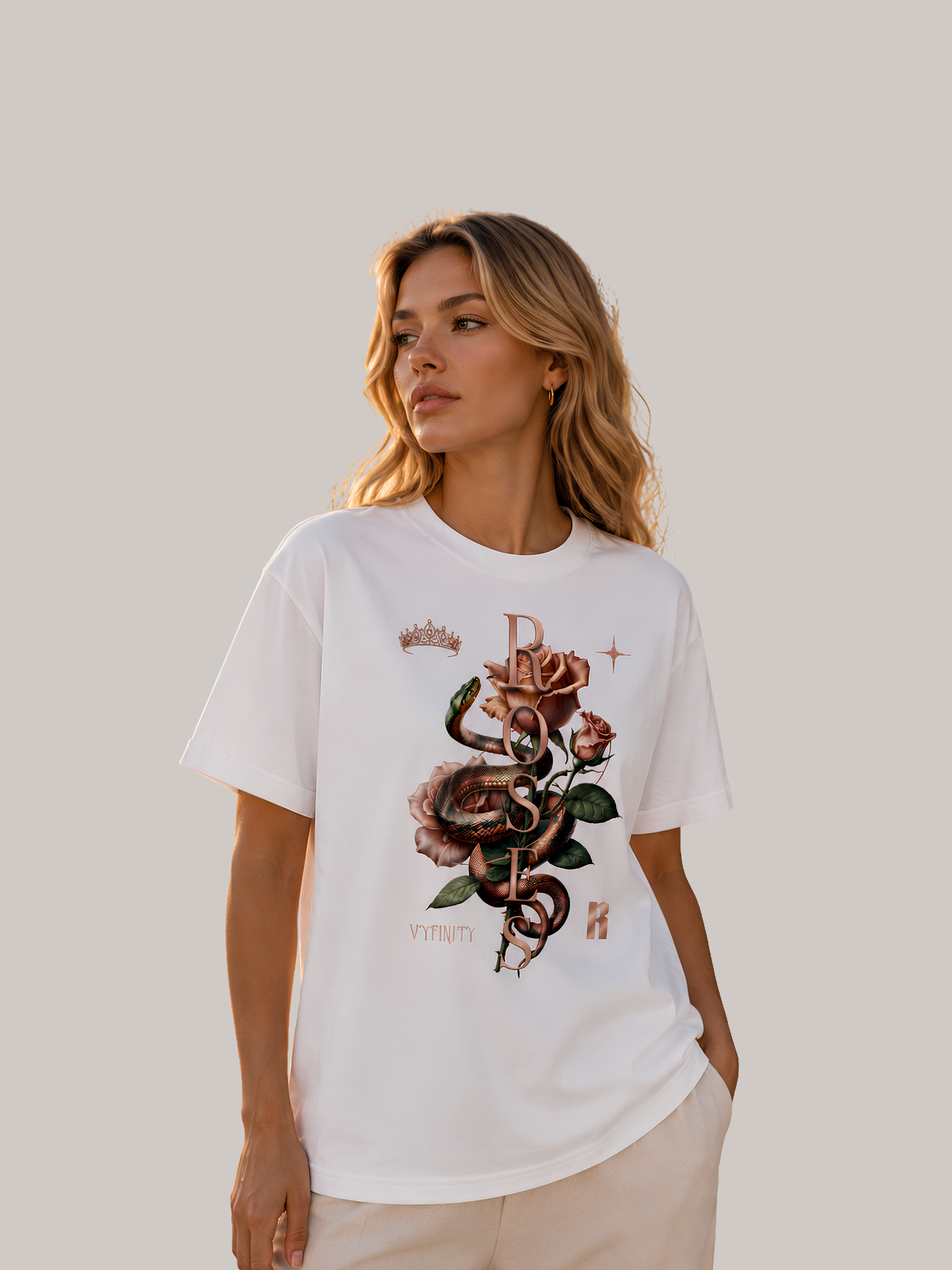 Elegante blonde Frau trägt ein weißes Unisex Classic Fit T-Shirt mit detailreichem Schlangen- und Rosenmotiv sowie dem Schriftzug „Roses“. Premium Baumwoll-Shirt im Luxury Streetwear-Stil mit floralem Snake-Print und dezenten Kronen-Details, fotografiert im modernen Editorial-Look.