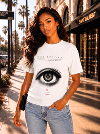 Weibliches Model trägt ein weißes VYFINITY „SEE BEYOND“ T-Shirt mit großem Augenmotiv und V-Logo, kombiniert mit hellblauer Jeans auf einer sonnigen, palmengesäumten Einkaufsstraße.