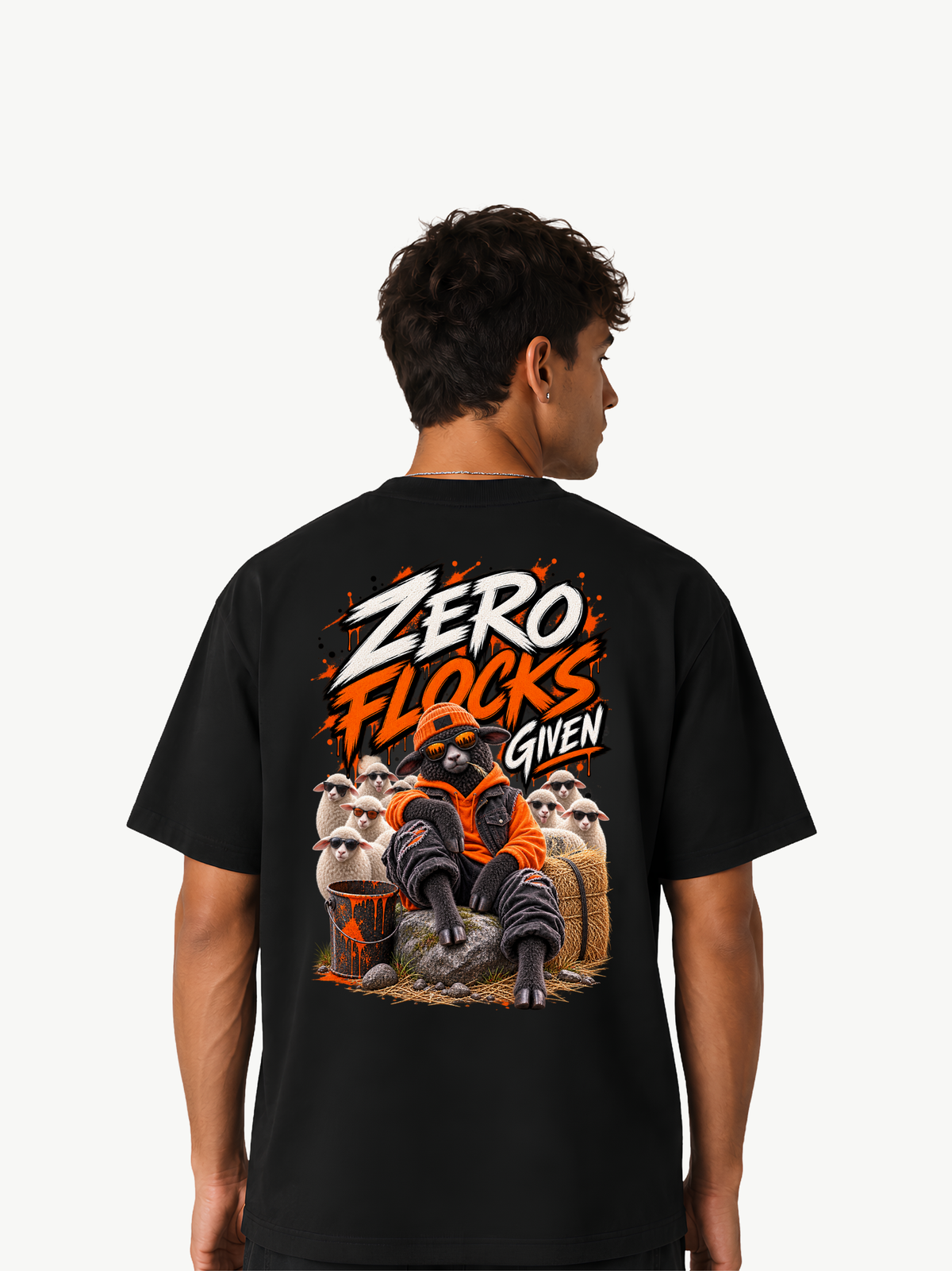Männliches Model trägt ein schwarzes VYFINITY Heavy T-Shirt mit großem Rückenprint „ZERO FLOCKS GIVEN“. Das Streetwear-Motiv zeigt ein schwarzes Schaf in orange-schwarzem Outfit vor einer Gruppe weißer Schafe.