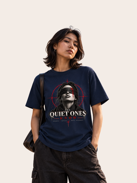 Damen Lifestyle-Mockup mit navyblauem VYFINITY Regular Fit T-Shirt aus 180 GSM Baumwolle und großem „THE QUIET ONES KNOW“-Frontprint mit schwarz-weißem Frauenporträt, Augenbinde und roten grafischen Akzenten.