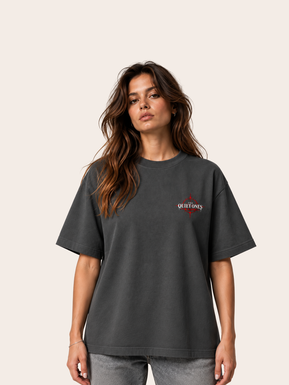 Anthrazitfarbenes VYFINITY Heavy T-Shirt mit 215 GSM in Oversized-Passform, Frontansicht an weiblichem Model, mit kleinem „THE QUIET ONES KNOW“-Brustprint in Weiß und Rot.