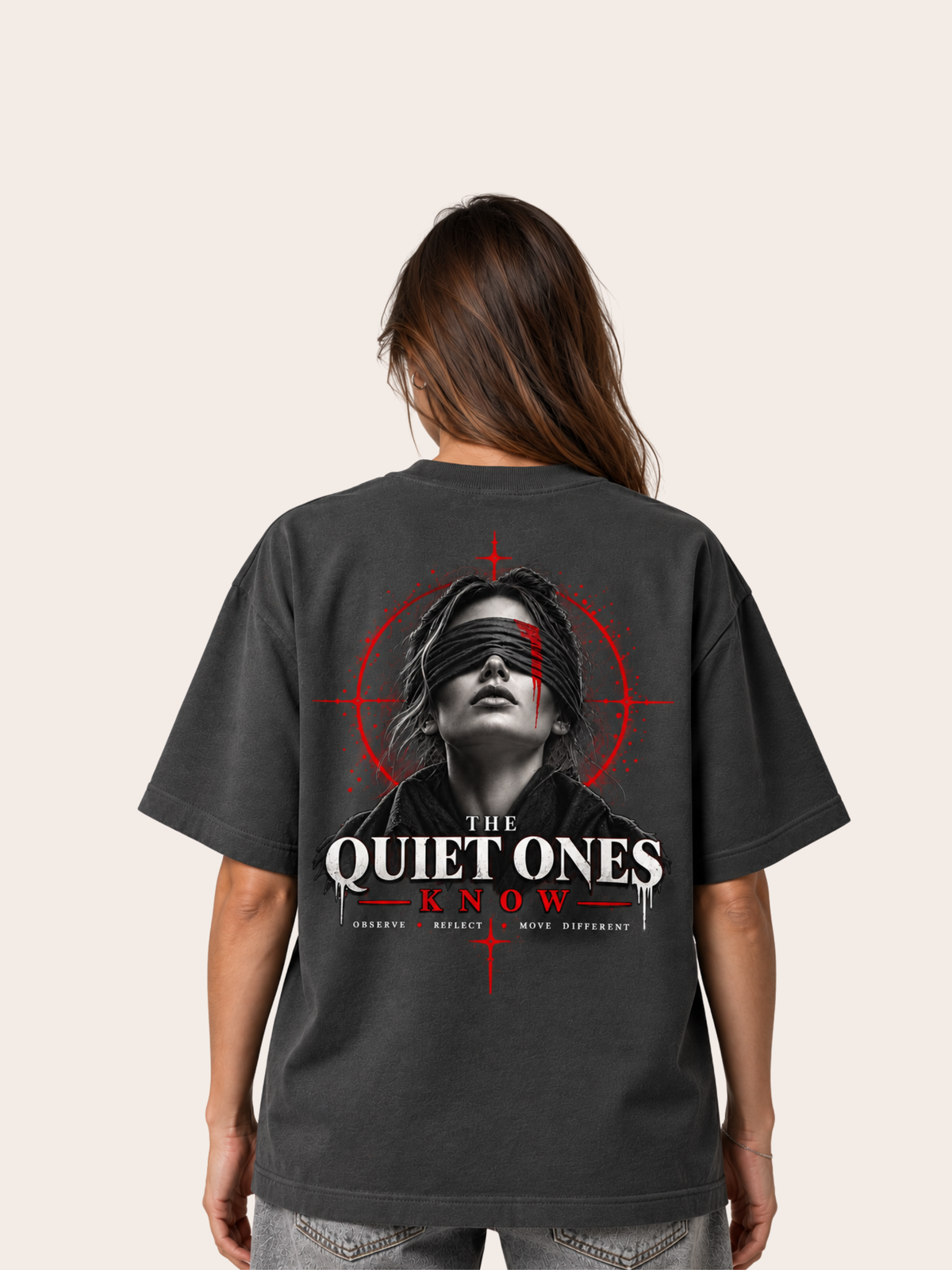 Anthrazitfarbenes VYFINITY Heavy T-Shirt mit 215 GSM in Rückansicht an weiblichem Model, mit großem „THE QUIET ONES KNOW“-Backprint, verbundenen Augen sowie roten und weißen grafischen Akzenten.