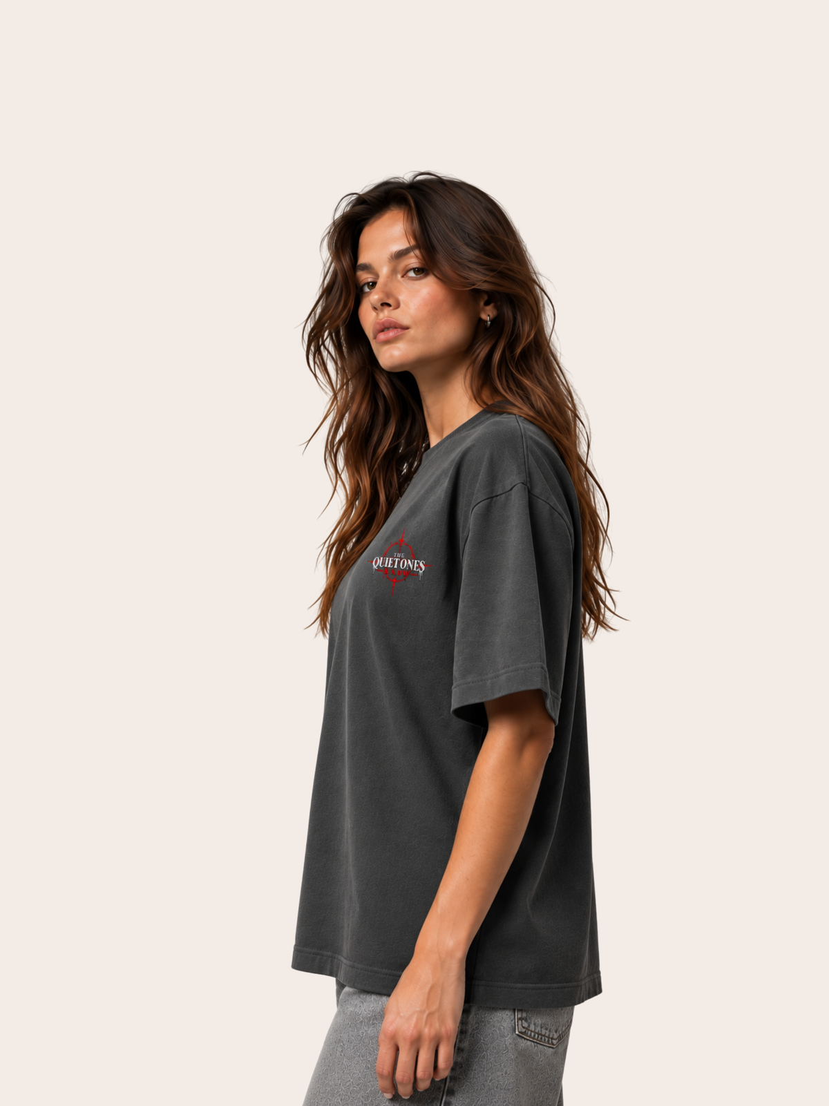 Anthrazitfarbenes VYFINITY Heavy T-Shirt mit 215 GSM in seitlicher Ansicht an weiblichem Model, Oversized-Passform und kleinem „THE QUIET ONES KNOW“-Brustprint in Weiß und Rot.