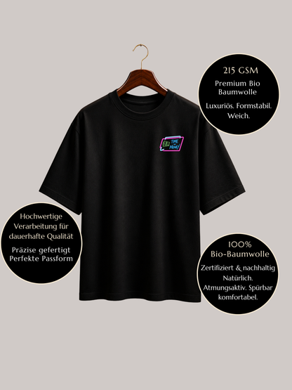 Schwarzes VYFINITY Relaxed Fit Premium T-Shirt aus 215 GSM Bio-Baumwolle auf Holzbügel mit „Time Money“-Brustlogo. Infografik zeigt hochwertige Verarbeitung, formstabile Qualität, weiches Tragegefühl, atmungsaktiven Stoff und 100 % zertifizierte Bio-Baumwolle – nachhaltige Premium Streetwear.