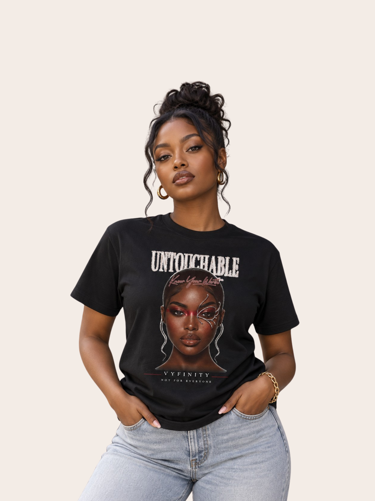 Frau trägt ein schwarzes VYFINITY T-Shirt mit großem „UNTOUCHABLE“-Frontprint und ausdrucksstarkem Frauenporträt mit grafischen Gesichtselementen. Darunter stehen VYFINITY und „NOT FOR EVERYONE“. Kombiniert mit heller Jeans für einen modernen Streetwear-Look.