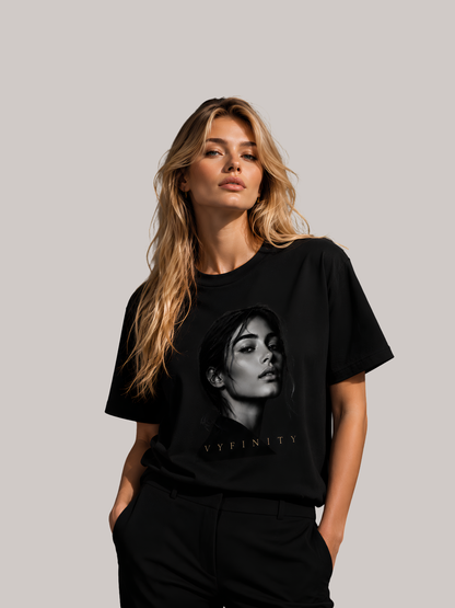 Junge Frau trägt ein schwarzes Vyfinity Classic Fit Unisex T-Shirt mit monochromem Frauenporträt und dezentem Vyfinity-Schriftzug. Modernes Premium Baumwoll-T-Shirt im minimalistischen Streetwear-Stil mit hochwertigem Fashion-Print und elegantem Urban-Look.