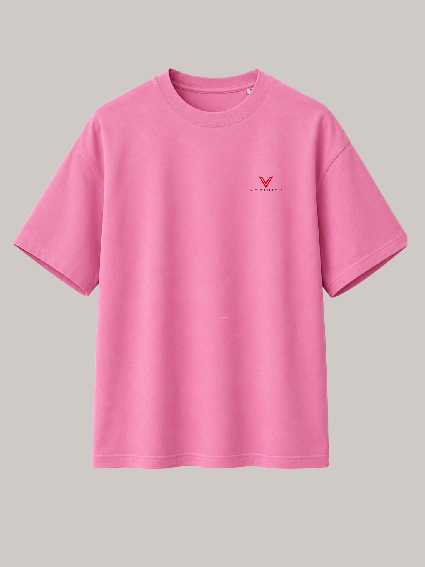 Pinkes VYFINITY Oversized Unisex T-Shirt mit kleinem rotem VYFINITY Logo auf der linken Brust. Minimalistisches Premium-Streetwear-Shirt mit lockerer Passform, kurzen Ärmeln und modernem Urban-Fashion-Design für Damen und Herren.