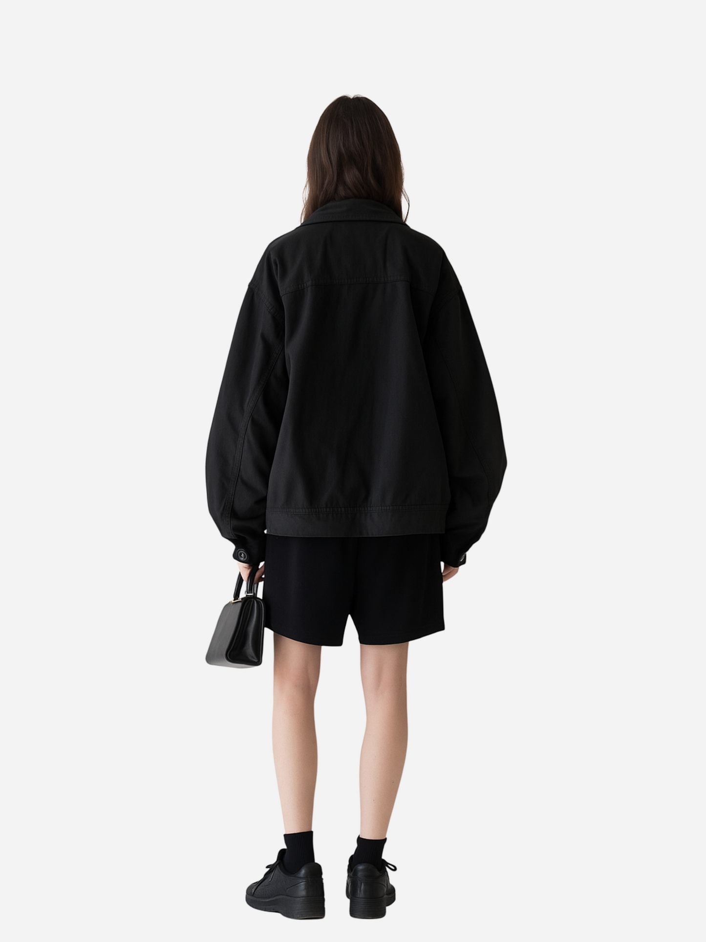 Streetwear Outfit Rückansicht: Frau trägt schwarzes Oversize T-Shirt Bio Code Rewritten, kombiniert mit lockeren Shorts, schwarzer Jacke und Sneakers. Minimalistischer Urban Geek Style mit cleaner Rückseite.