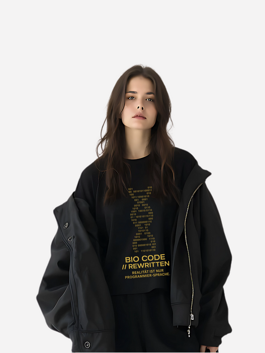 Schwarzes Oversize T-Shirt mit gelbem Bio Code Rewritten Print, stylischer DNA-Strang aus Binärcode mit dem Slogan „BIO CODE // REWRITTEN – Realität ist nur Programmier-Sprache“. Urban Streetwear für Damen und Herren.