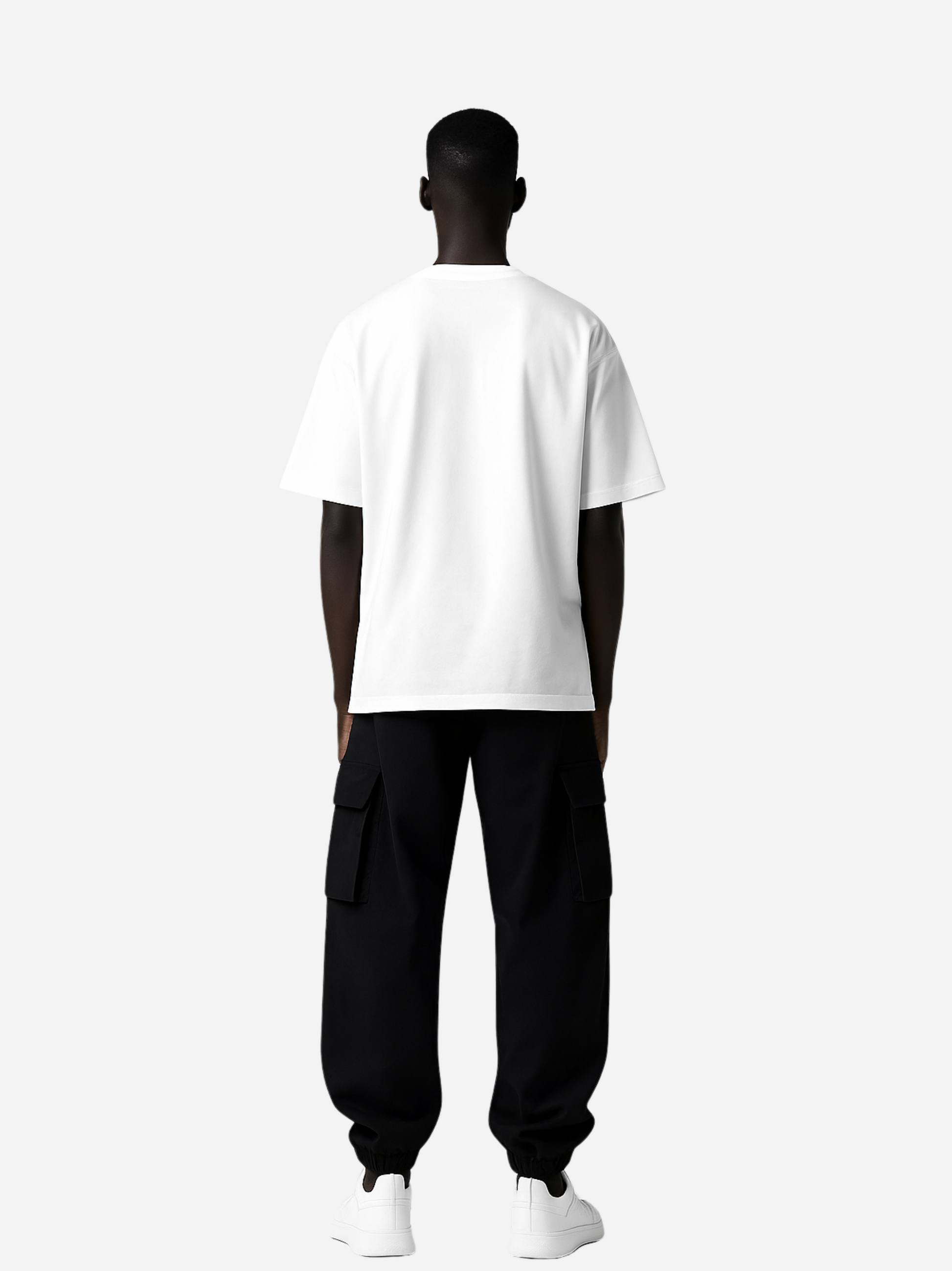 Rückansicht eines weißen Oversized T-Shirts ohne Print, getragen von schwarzem Mann mit schwarzer Cargo-Hose und weißen Sneakern
