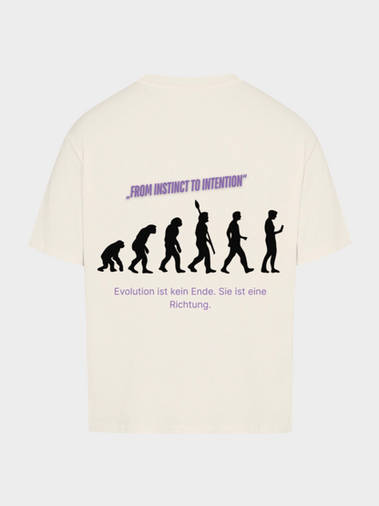 Oversized T-Shirt in Beige mit großem Rückenprint. Schwarze Silhouetten zeigen die Evolution vom Affen zum modernen Menschen. Darüber violetter Schriftzug „FROM INSTINCT TO INTENTION“, darunter der deutsche Text „Evolution ist kein Ende. Sie ist eine Richtung.“ Streetwear mit philosophischem Design.