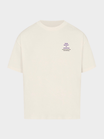 Oversized T-Shirt in Beige mit kleinem Frontprint links auf der Brust. Violetter Schriftzug „FROM INSTINCT TO INTENTION“ mit Zusatz in Deutsch: „Evolution ist kein Ende. Sie ist eine Richtung.“ Minimalistisches Streetwear-Design mit philosophischer Botschaft.