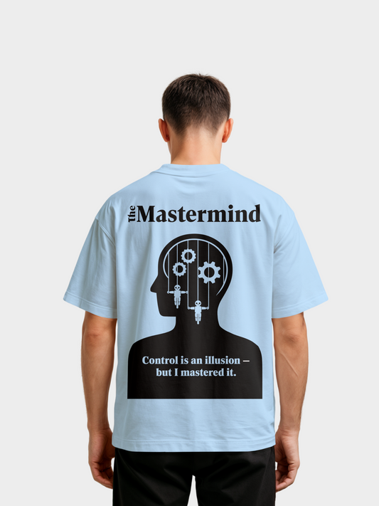 Oversized T-Shirt in Hellblau, Rückansicht, getragen von einem Mann. Auf der Rückseite ein großes schwarzes Grafikdesign: Silhouette eines Kopfes mit Zahnrädern und Fäden wie Marionettensteuerung. Darüber der Schriftzug „The Mastermind“, darunter der Text „Control is an illusion – but I mastered it.“. Modernes Streetwear-Statement-Shirt.