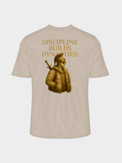 Beiges T-Shirt mit goldenem Rückenprint „Discipline Builds Dynasties“. Illustration eines modernen Kriegers mit Sonnenbrille, Kette, dicker Jacke und Schwert auf dem Rücken. Edles Streetwear-Design mit Fokus auf Disziplin, Stärke und Erfolg.