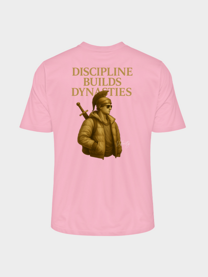 Rosa T-Shirt mit goldenem Rückenprint „Discipline Builds Dynasties“. Illustration eines modernen Kriegers mit Schwert, Sonnenbrille und Daunenjacke. Stilvolles Streetwear-Design mit kraftvoller Botschaft über Disziplin, Stärke und Erfolg.
