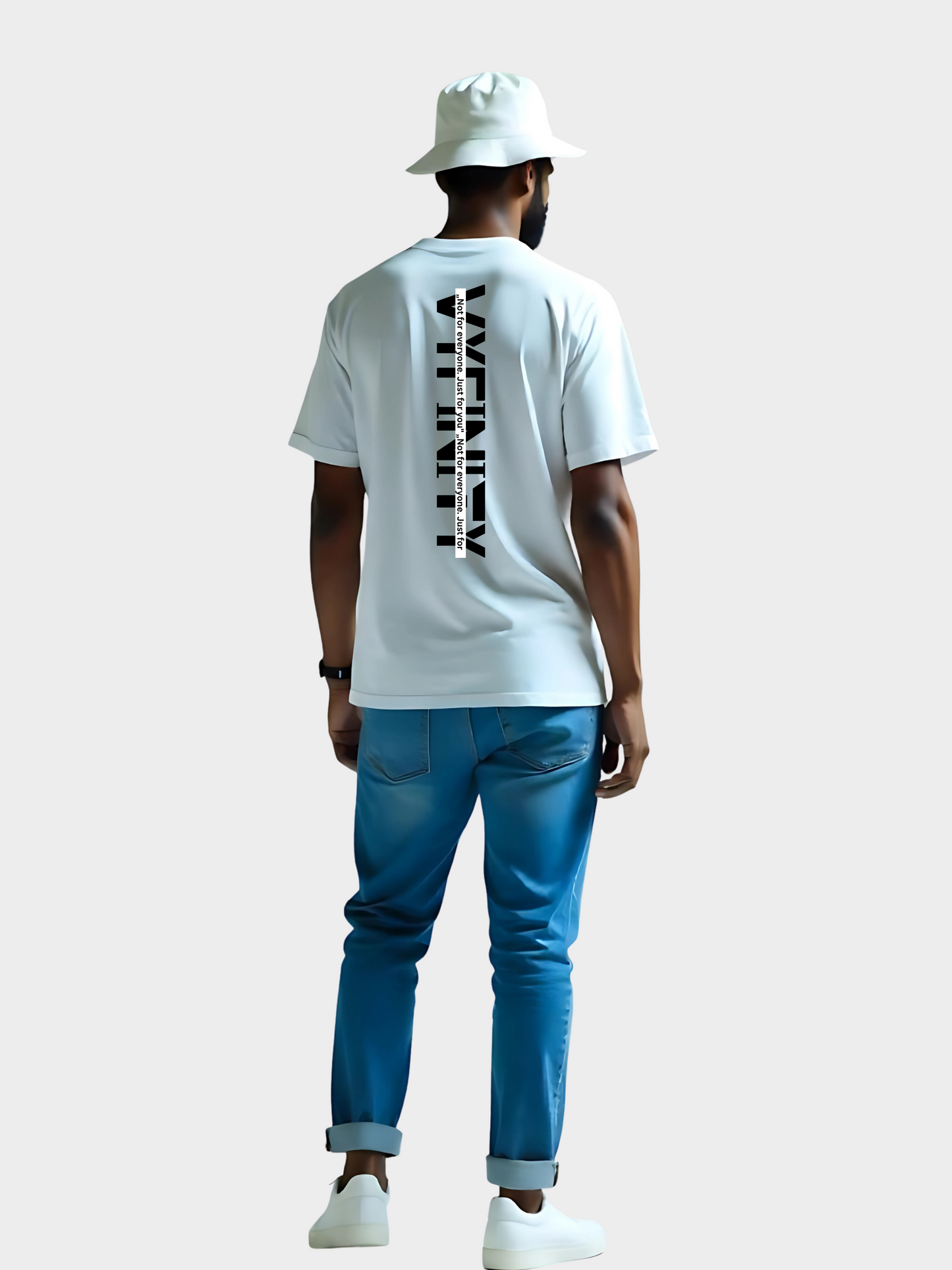 Vyfinity Oversize T-Shirt in Weiß mit auffälligem vertikalem Backprint „VYFINITY“. Schwarzer Textdruck entlang der Rückenmitte mit dem Slogan „Not for everyone, just for you“. Moderner Streetwear-Look mit Bucket Hat und blauer Jeans kombiniert.