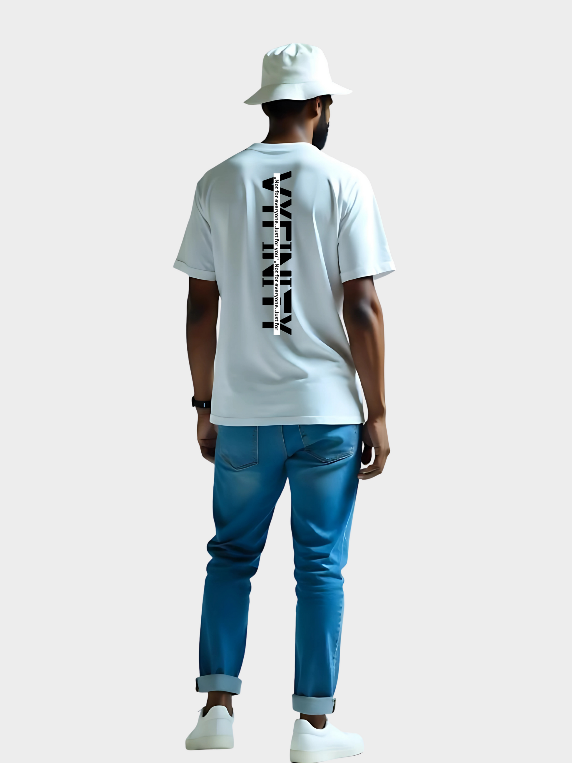 Vyfinity Oversize T-Shirt in Weiß mit auffälligem vertikalem Backprint „VYFINITY“. Schwarzer Textdruck entlang der Rückenmitte mit dem Slogan „Not for everyone, just for you“. Moderner Streetwear-Look mit Bucket Hat und blauer Jeans kombiniert.