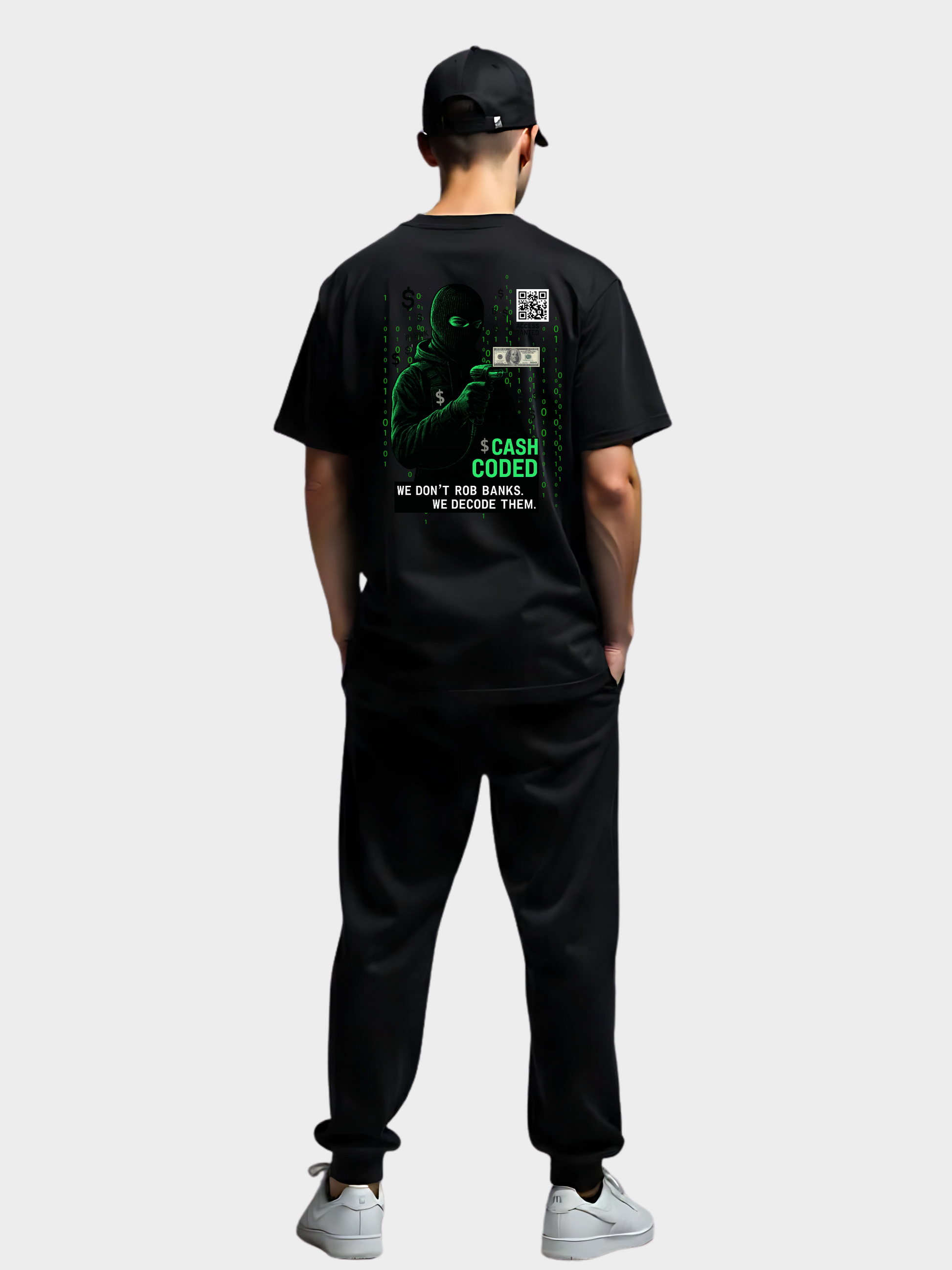 Rückansicht eines schwarzen Vyfinity T-Shirts „Cash Coded“ mit großem Hacker-Design in Grün, getragen von einem Model mit schwarzer Cap, schwarzer Hose und weißen Sneakern.