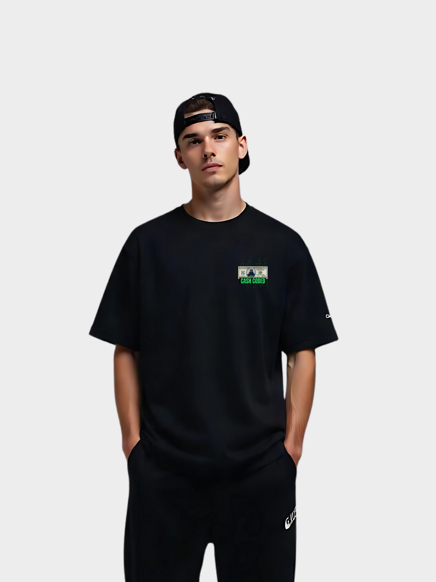 Schwarzes Vyfinity T-Shirt „Cash Coded“ mit kleinem grünen Frontprint auf der linken Brust, getragen von einem Model mit schwarzer Cap und schwarzer Hose.