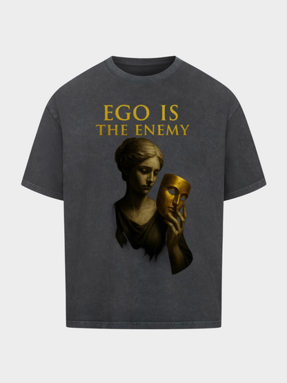 Vintage Black Oversize T-Shirt im Washed-Look mit goldenem Schriftzug „Ego is the Enemy“. Design zeigt eine klassische Statue mit goldener Maske in der Hand – Symbol für Wahrheit, Identität und Demut. Trendiges Streetwear-Shirt mit künstlerischer Tiefe.