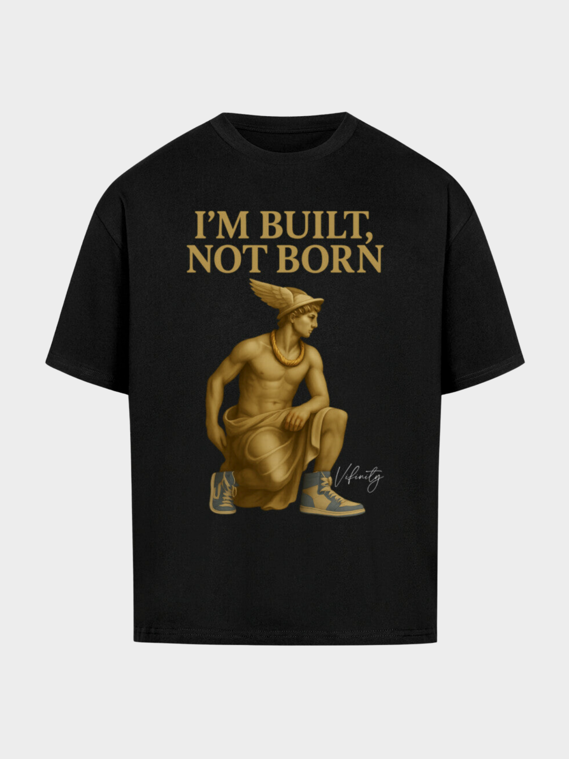 Schwarzes Oversize T-Shirt mit goldener Statue im antiken Look, kombiniert mit modernen Sneakers. Oben goldener Schriftzug „I’M BUILT, NOT BORN“ – urbaner Streetwear-Style mit starkem Motivations-Statement.