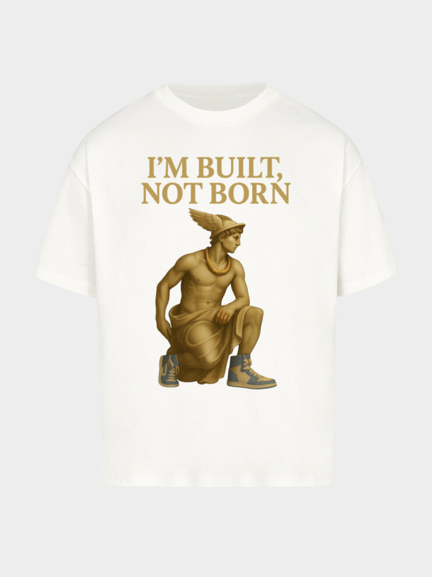 Weißes Oversize T-Shirt Flatlay mit goldener Statue im antiken Stil, kombiniert mit modernen Sneakers. Goldener Aufdruck „I’M BUILT, NOT BORN“ verleiht dem Design einen kraftvollen Motivations-Charakter im Streetwear-Look.