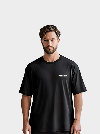 Schwarzes Oversize T-Shirt mit minimalistischem weißen Vyfinity Frontlogo auf der Brust. Moderner Streetwear-Look, schlicht und elegant – ideal für einen cleanen urbanen Style.