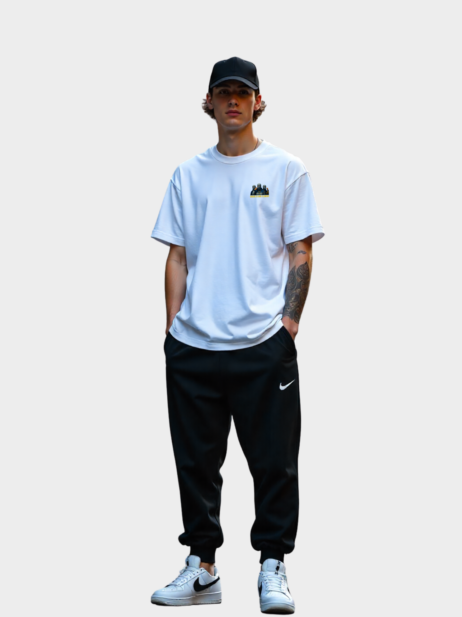 Vyfinity Storm Crew T-Shirt in Weiß, Modelshot Frontansicht. Kleiner Brustprint mit drei maskierten Figuren, goldener Schrift „Storm Crew“ und dem Spruch „Chaos is our Element“. Lockerer Oversized Streetwear Look mit Cap und Joggerpants.
