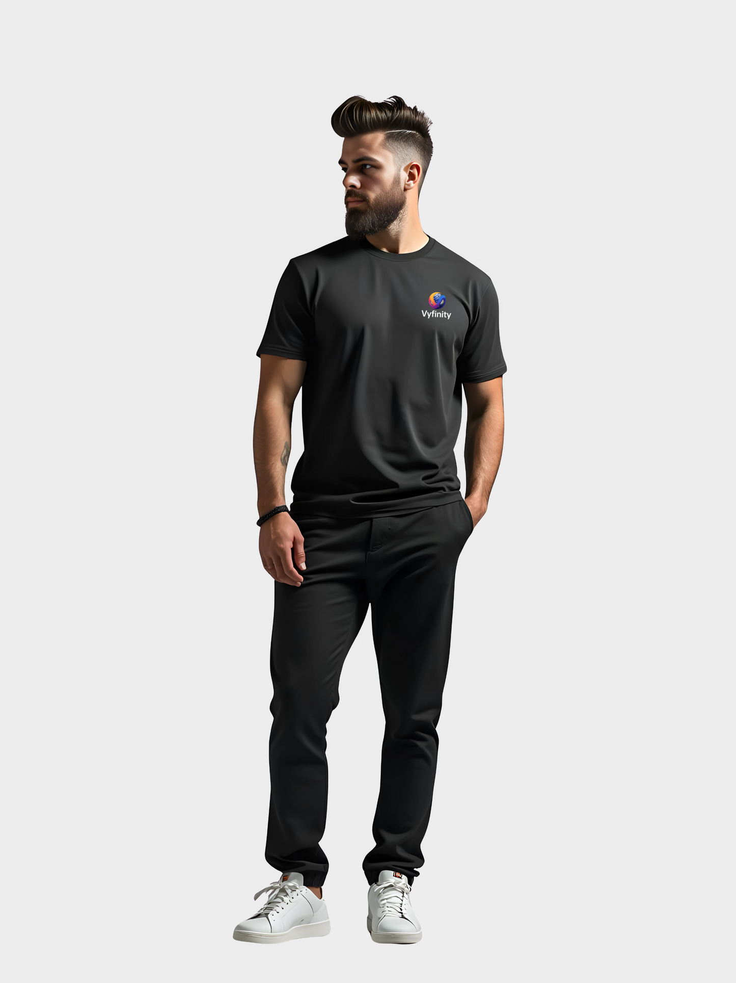 Vyfinity T-Shirt in Schwarz mit buntem Color-Logo auf der Brust, getragen von Model im modernen Lifestyle-Look. Streetwear-Style kombiniert mit Sneakers und schwarzer Hose für urbanes Outfit.