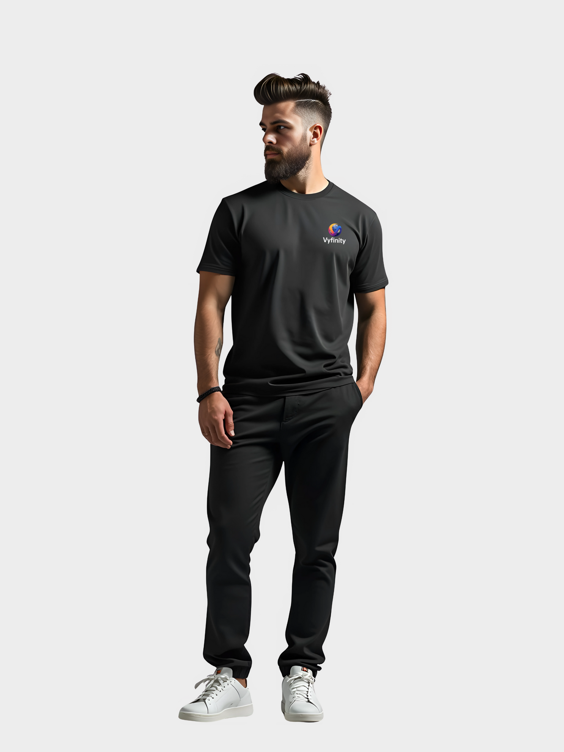 Vyfinity T-Shirt in Schwarz mit buntem Color-Logo auf der Brust, getragen von Model im modernen Lifestyle-Look. Streetwear-Style kombiniert mit Sneakers und schwarzer Hose für urbanes Outfit.