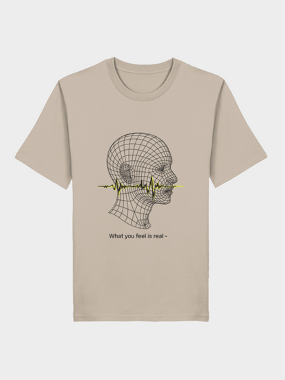 Beiges Vyfinity Unisex T-Shirt mit futuristischem Linienkopf-Motiv. Durch den Kopf verläuft eine gelbe Soundwave, darunter der Schriftzug „What you feel is real –“. Minimalistisches Graphic Tee im modernen Streetwear-Stil.
