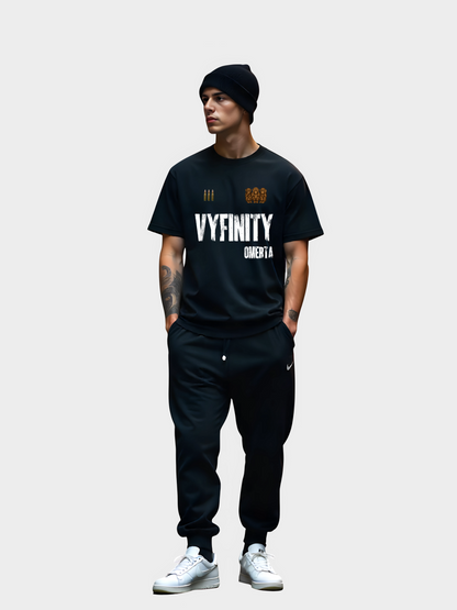 Vyfinity Omertà T-Shirt Schwarz Vorderansicht mit großem Frontprint, getragen von Model mit schwarzer Mütze und Tattoos